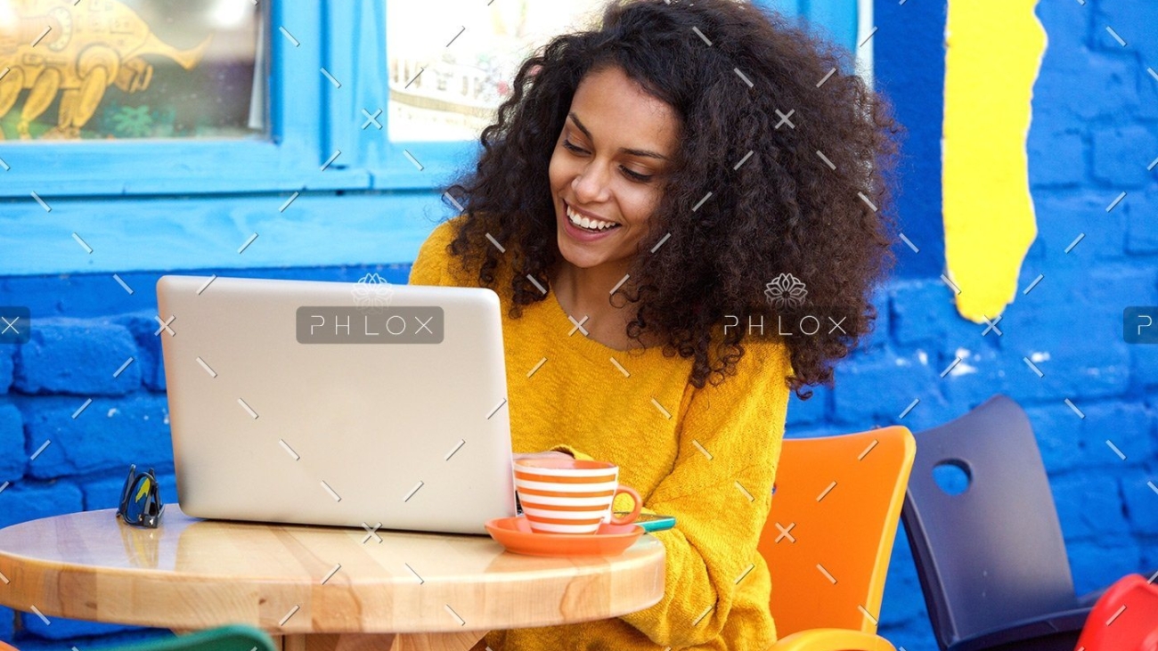 demo-attachment-29-happy-young-woman-sitting-at-outdoor-cafe-using-PFFBJ93